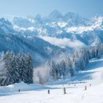 Panorama de montagnes enneigées avec des skieurs sur les pistes