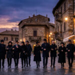 Neuf personnes élégantes en manteaux et chapeaux noirs se promènent sur une rue pavée d'une ville historique italienne au crépuscule.