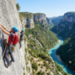 Deux grimpeurs en paroi au-dessus des eaux turquoise des Gorges du Verdon en France.